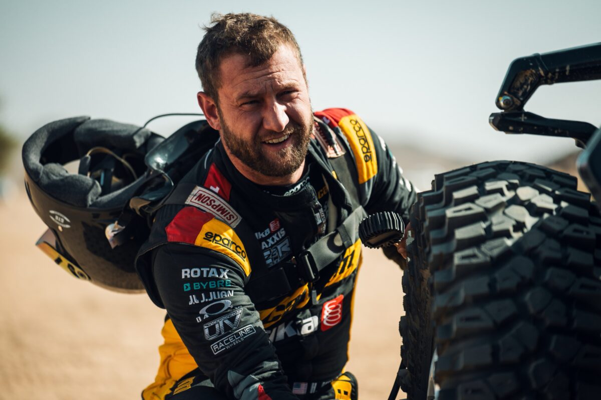 Maxxis athlete next to SXS in desert